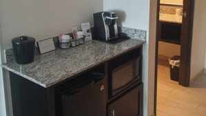 A kitchenette with a coffee machine, a trash bin, and a small cabinet. - Holiday Inn Express & Suites Golden - Denver Area by IHG (Golden)
