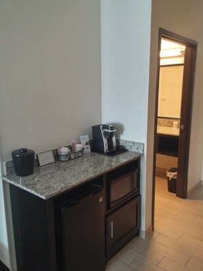 A kitchenette with a coffee machine, a trash bin, and a small cabinet. - Holiday Inn Express & Suites Golden - Denver Area by IHG (Golden)