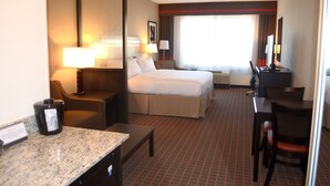A hotel room with a bed, a desk, a chair, a coffee maker, and a television. - Holiday Inn Express & Suites Golden - Denver Area by IHG (Golden)