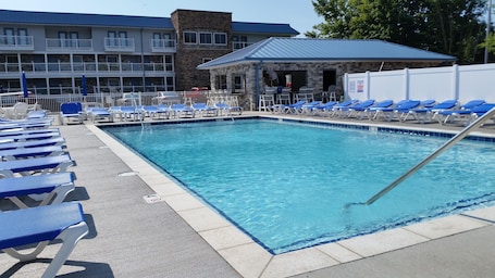 Una piscina al aire libre de temporada, sillones reclinables de piscina