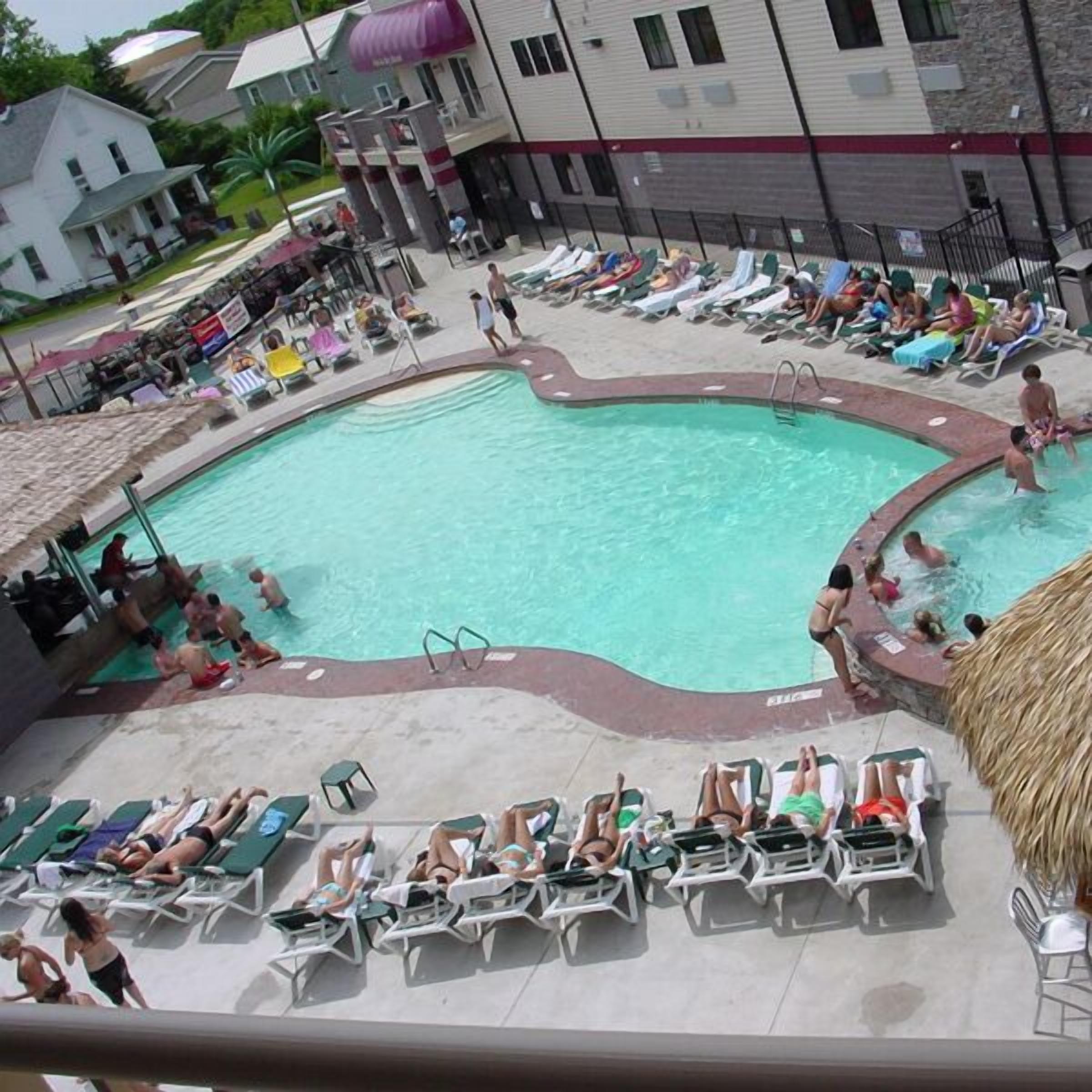 Un espace piscine comprenant des chaises longues et une plage autour de la piscine.