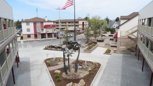 A courtyard with a flagpole, outdoor seating, and a fountain. - Put-In-Bay Resort and Conference Center (Put-in-Bay)
