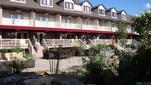 A multi-story hotel with balconies, outdoor seating, and a stone pathway. - Put-In-Bay Resort and Conference Center (Put-in-Bay)
