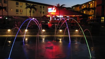 A nighttime scene with a water fountain display featuring multiple arcs of light.