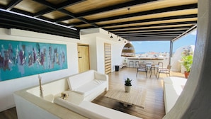A modern interior with a white sofa, a painting, and a wooden ceiling. - Ocean Breeze (Santo Domingo)