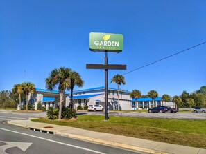 Un Garden Inn & Suites con techo azul y palmeras en primer plano.