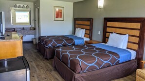 Une chambre d’hôtel avec deux lits, une kitchenette, une salle de bain et un petit coin salon.
