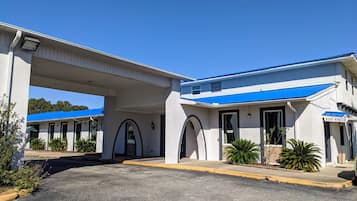 A building with a blue roof, white walls, and a covered entrance area.