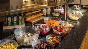 A buffet area with various food options, including salads, fruits, and a variety of dishes in glass bowls.
