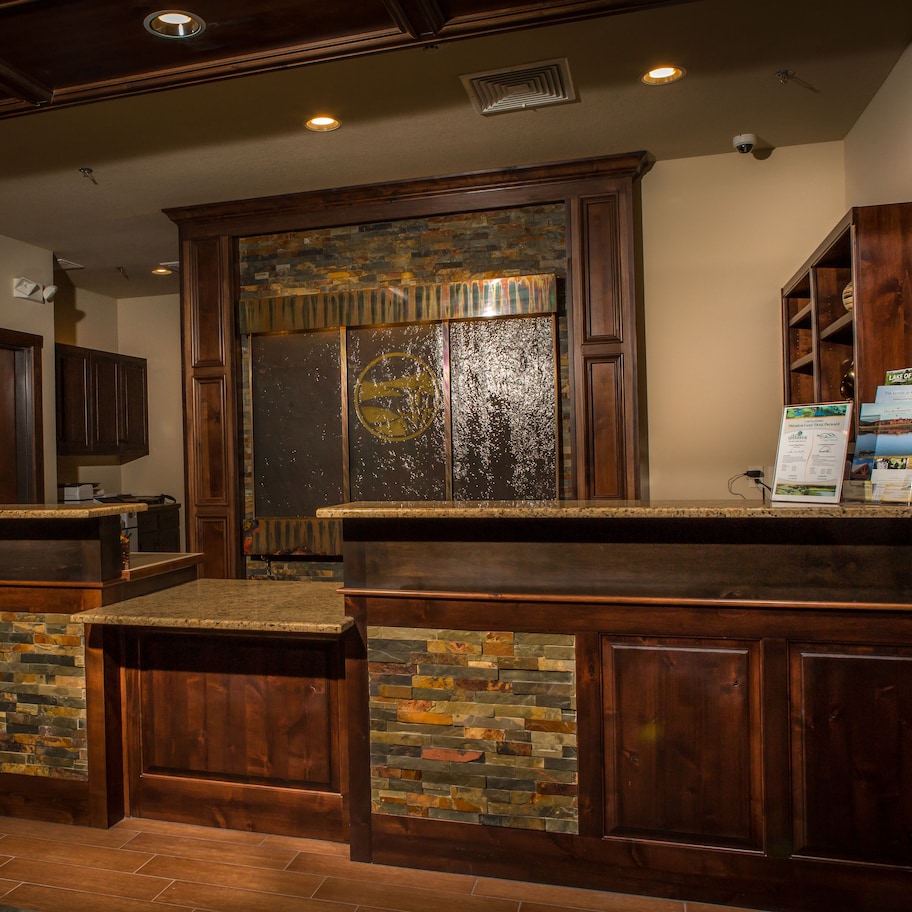A bar area with wooden counters and stone accents, a stone wall, and a wooden door.
