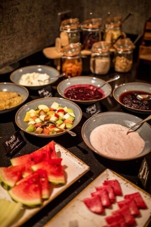 A buffet with various food items including fruit salad, watermelon slices, and different types of sauces. - Station Hotel Aberdeen (Aberdeen)