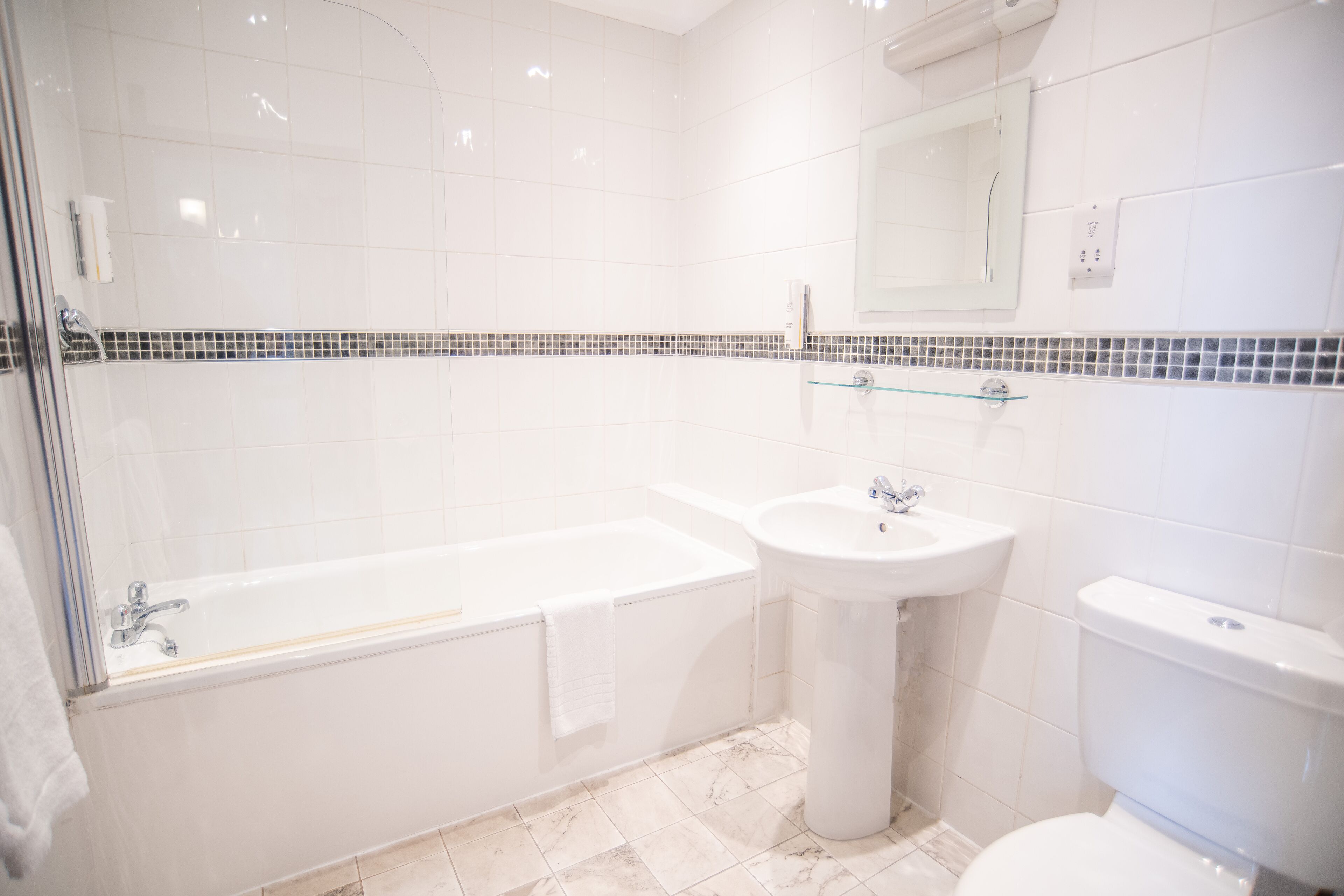A modern bathroom with a bathtub, sink, and toilet.