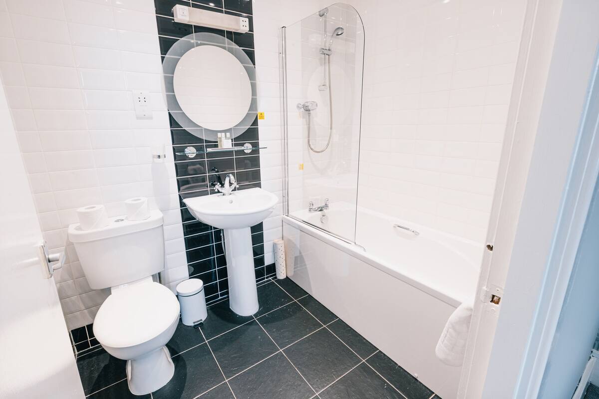 A modern bathroom with a toilet, sink, and shower.