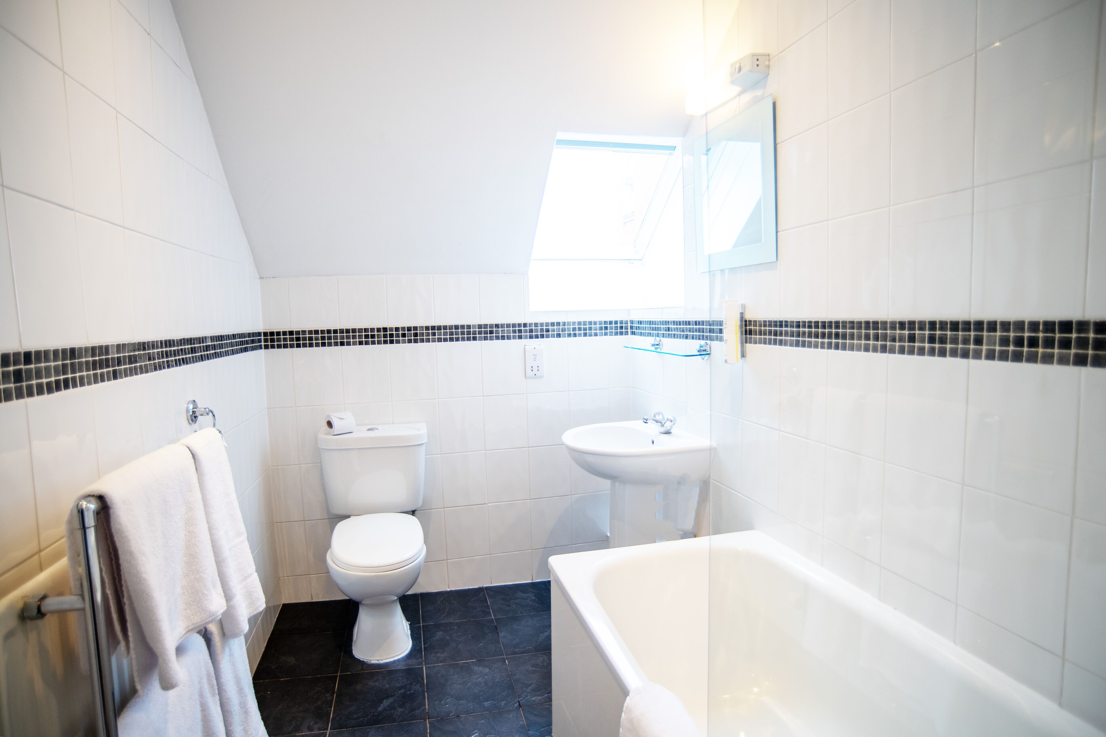Une salle de bain moderne équipée de toilettes, d’un lavabo et d’une baignoire.