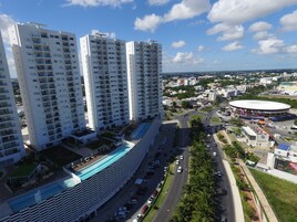 Un edificio de gran altura con varios pisos, una piscina y un estadio circular.