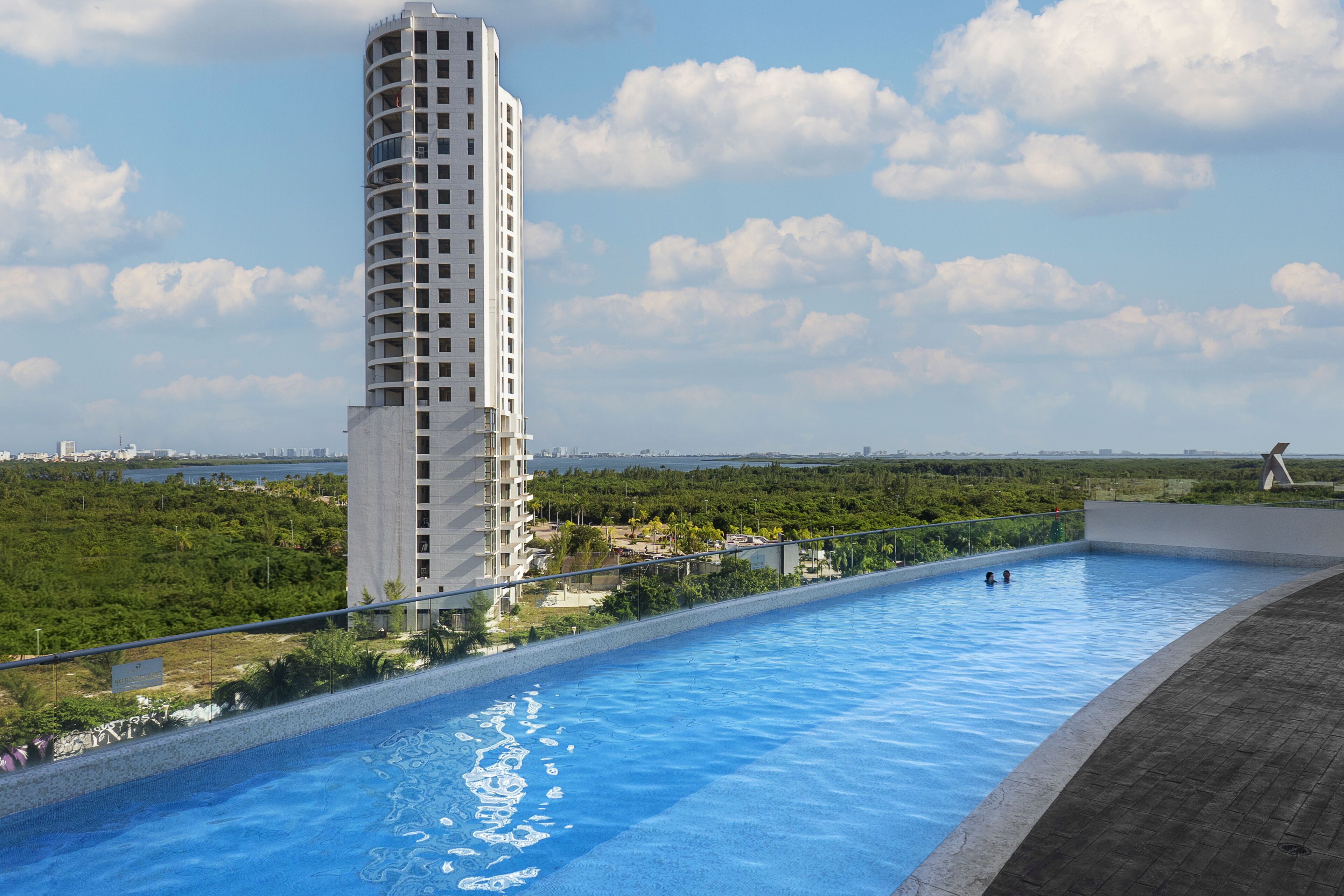 A modern building with a pool adjacent to a landscaped area.