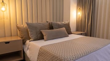 A modern bedroom with a large bed, a nightstand, and a wall-mounted light fixture.
