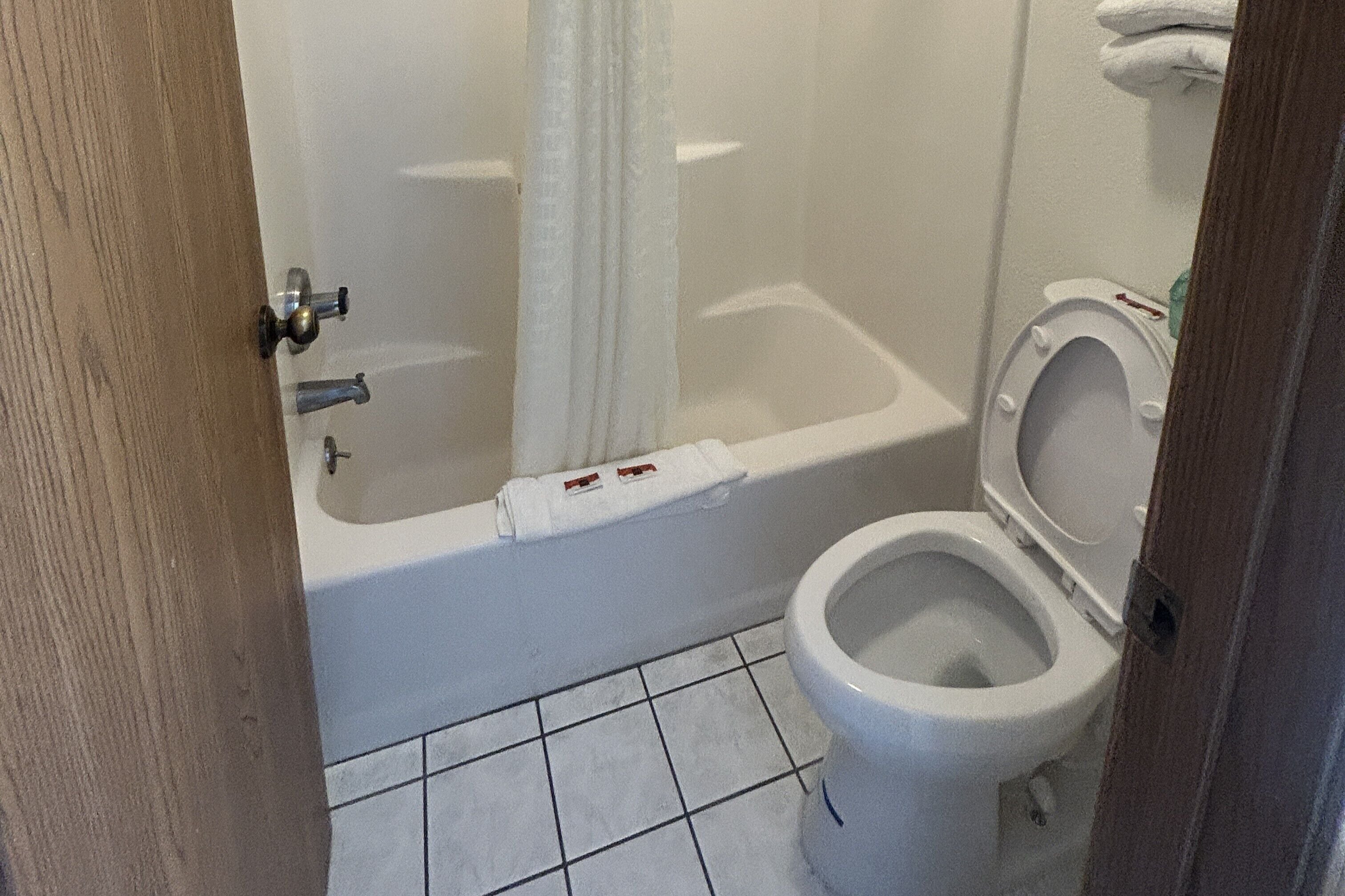 Un baño con bañera, inodoro y cortina de ducha.