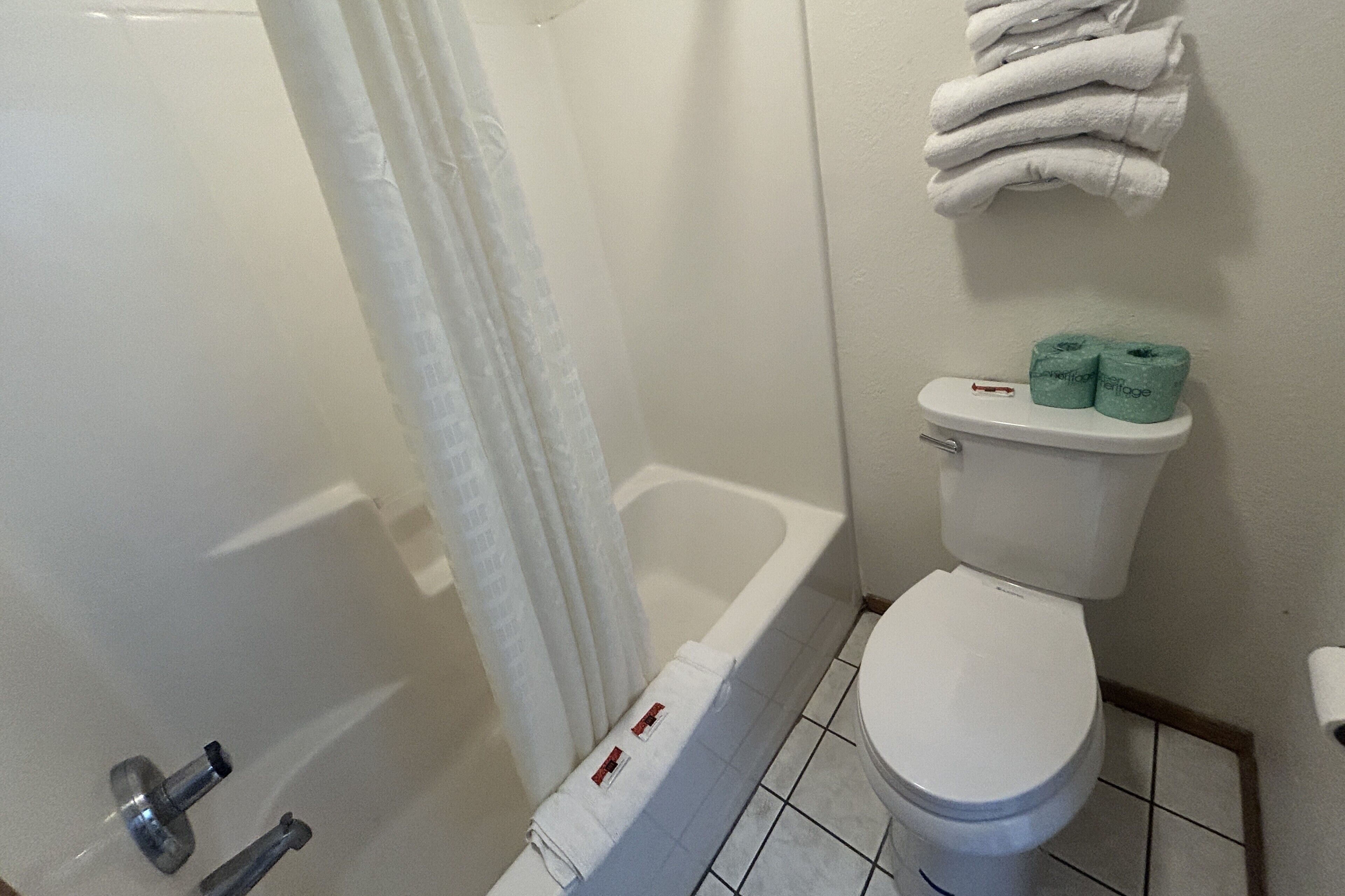 Une salle de bain équipée d’une baignoire, de toilettes et d’un porte-serviettes avec des serviettes.