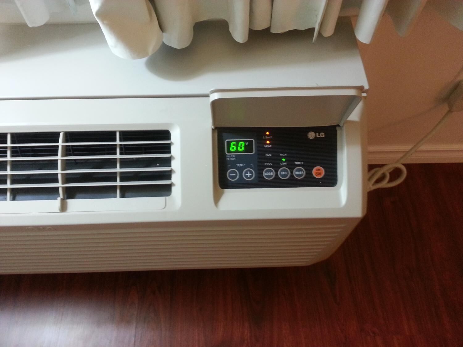A white portable heater with a digital display showing 60°F, control buttons for heat, fan, and timer, and an LG logo.