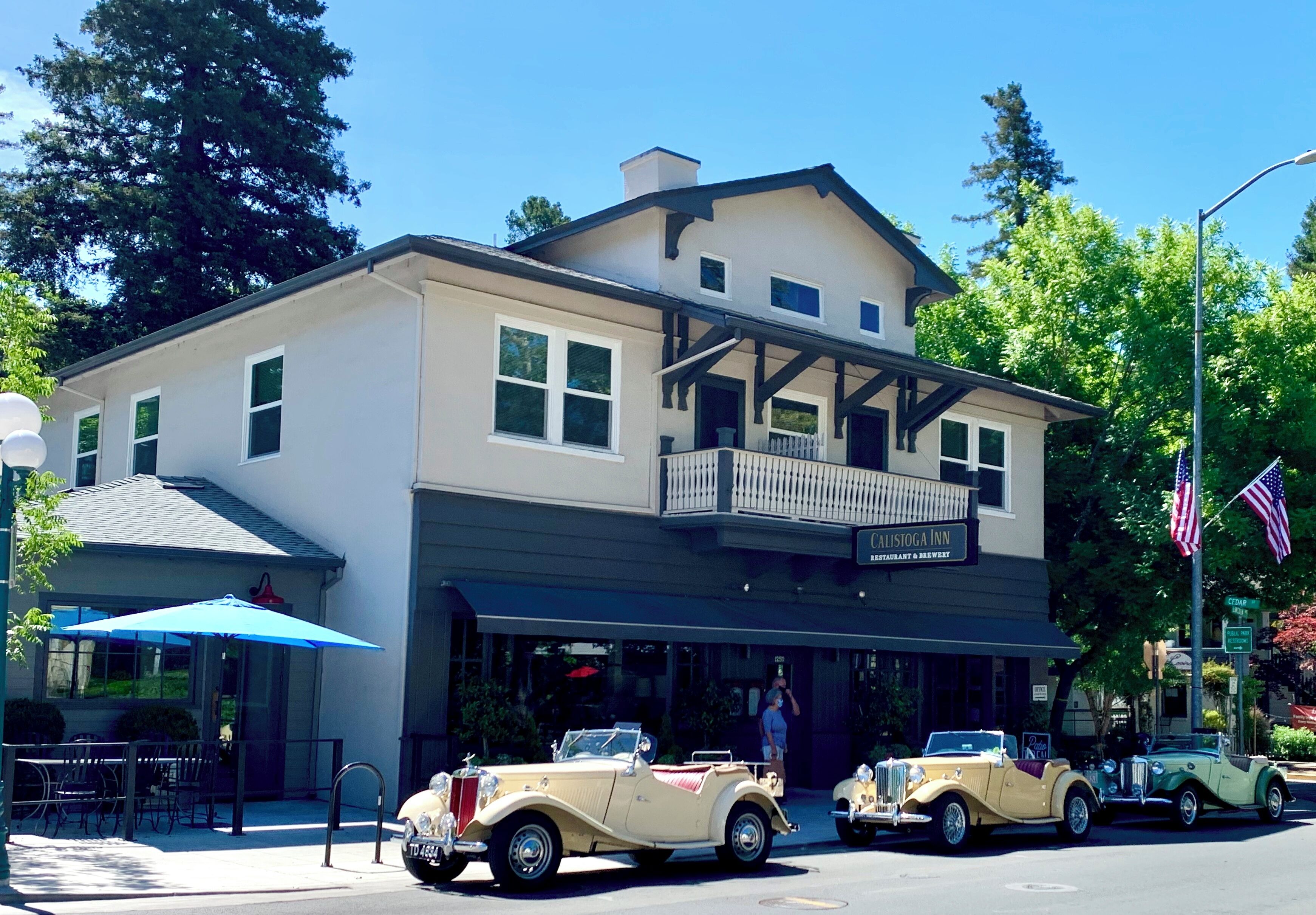 A building with a restaurant named 'Calistoga Inn' on the ground floor, featuring a balcony and a blue awning.