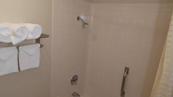 A bathroom with a bathtub, toilet, and towel rack.