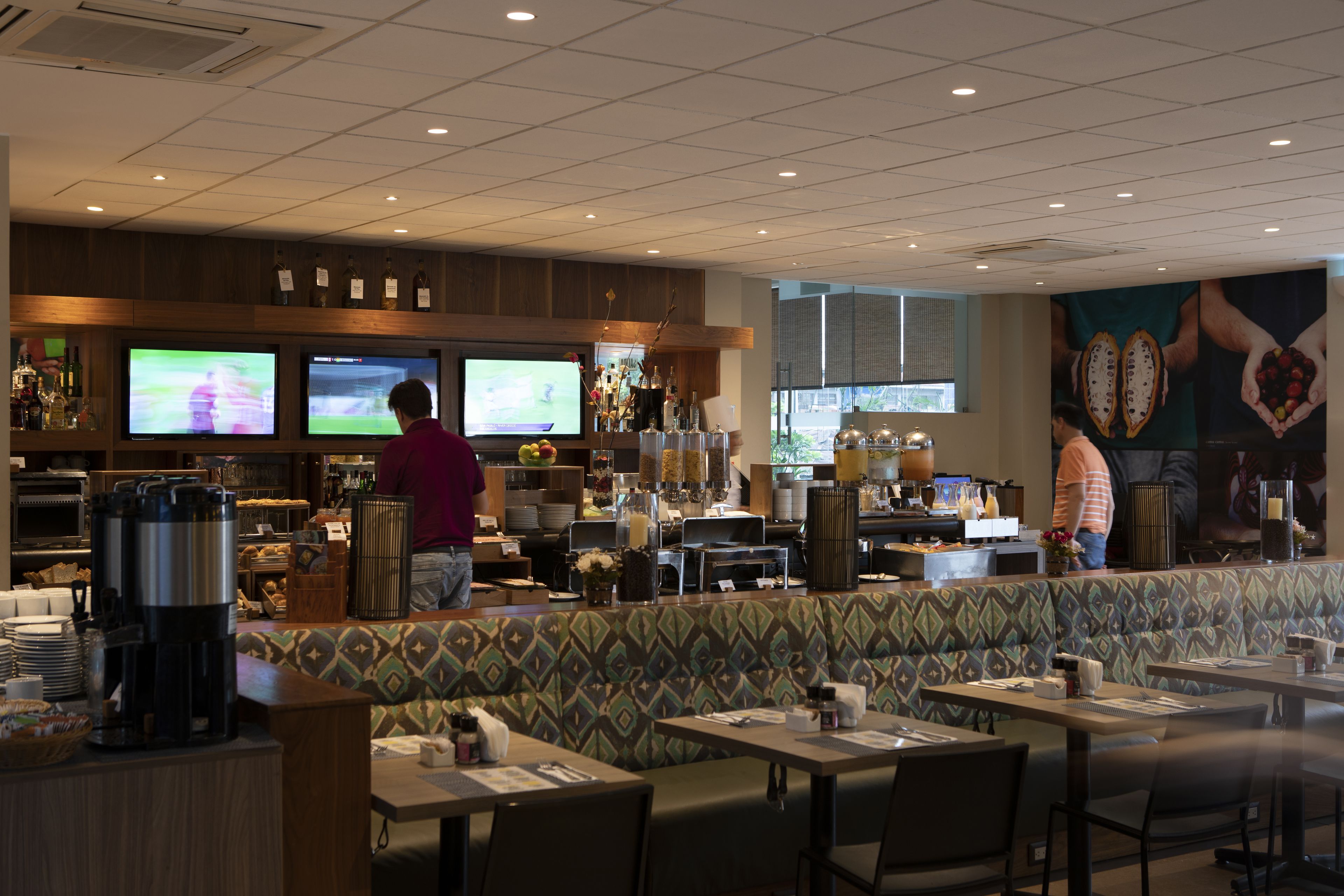 A restaurant with multiple TVs, a bar area, and seating.