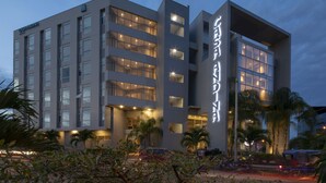Ein modernes Hotel mit mehreren Etagen, großen Fenstern und einer gut beleuchteten Fassade.