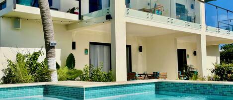 A two-story building with a swimming pool in front.
