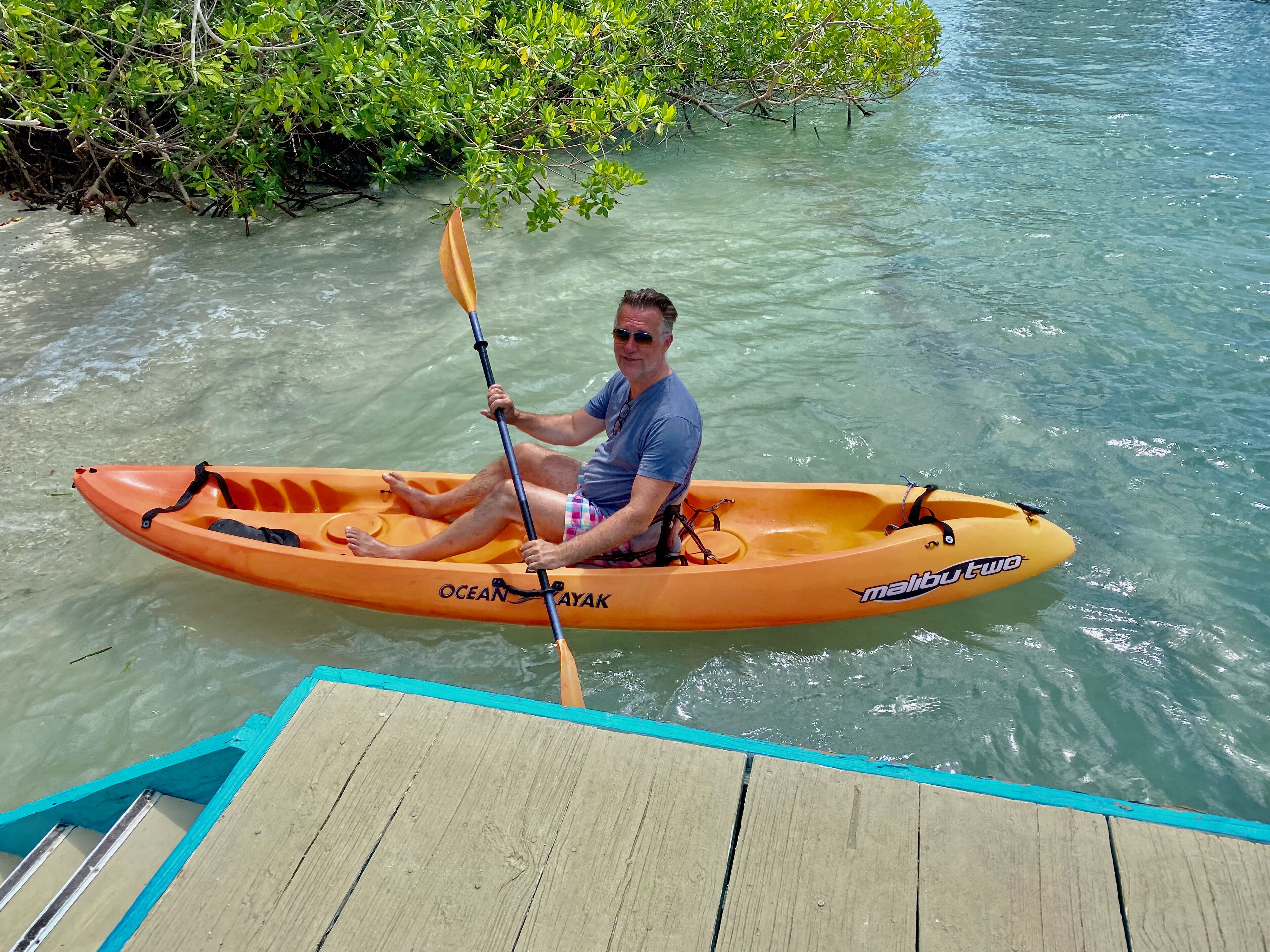 Un hombre en un kayak naranja con la marca 