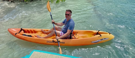 Un hombre en un kayak naranja con la marca