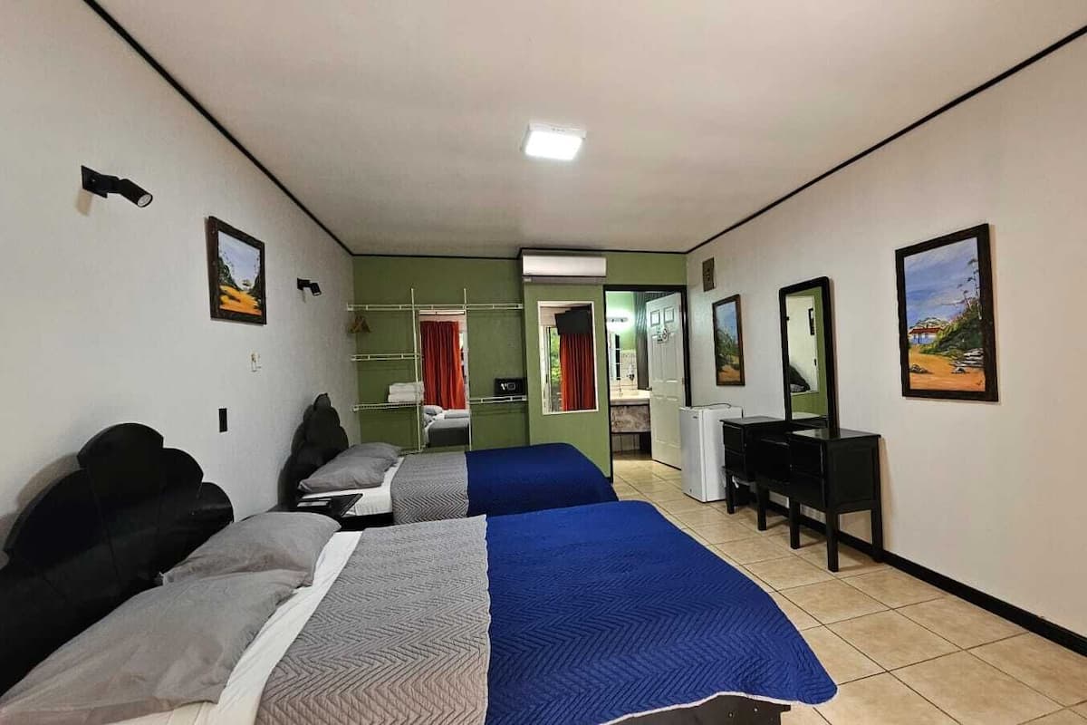 Habitación estándar, 2 camas matrimoniales, vista a la alberca | Ropa de cama de alta calidad y caja de seguridad en la habitación