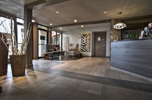 A modern lobby with a reception desk, seating area, and decorative elements.