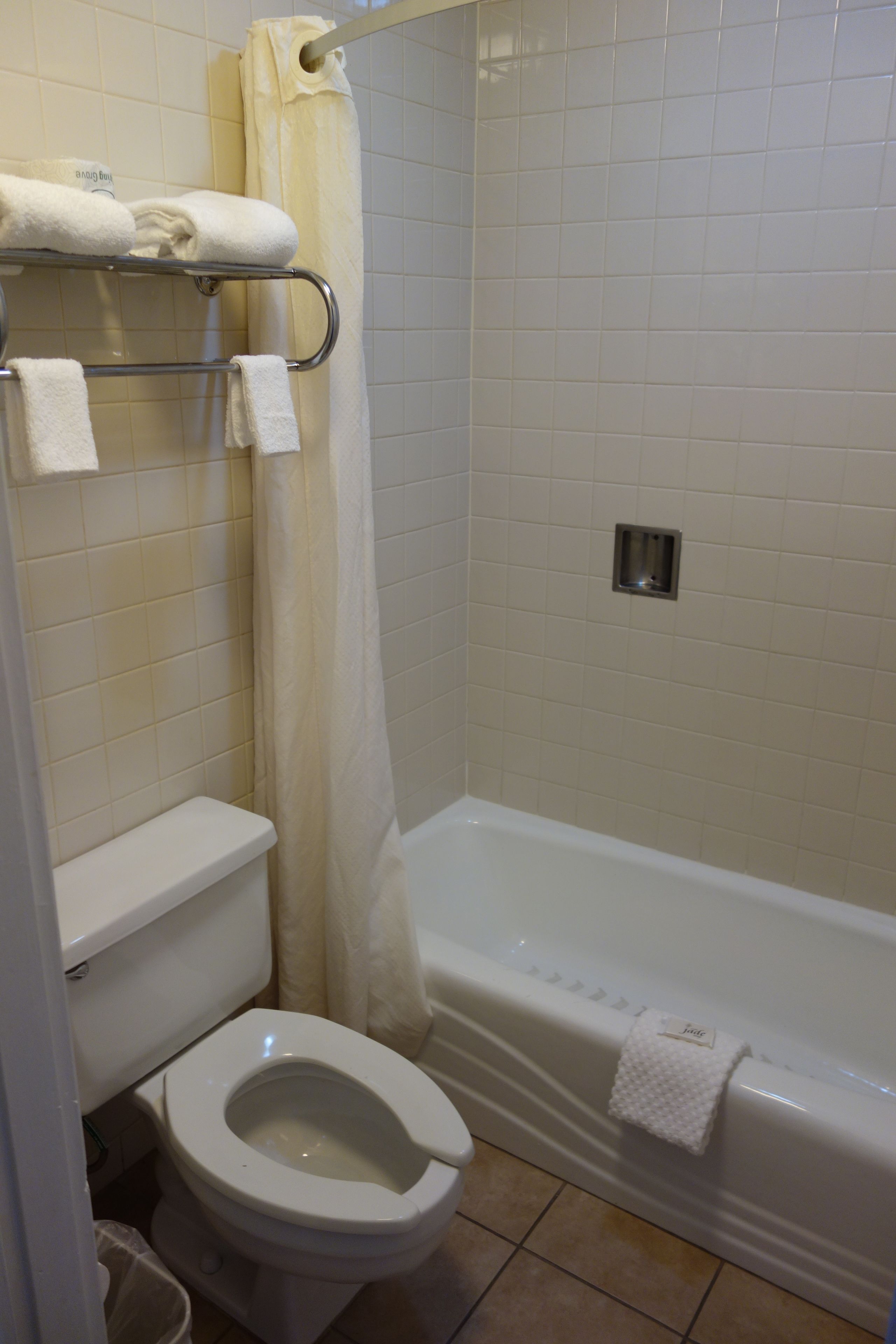 Un baño con inodoro, bañera y cortina de ducha.