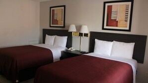 A hotel room with two beds, each with a dark red bedspread and white pillows. There are two wall-mounted lamps with white shades and a framed abstract painting above each bed. - VIP Inn and Suites (Huntsville)