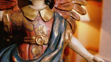 Eine Statue eines Engels mit Flügeln, Heiligenschein und goldenem Gürtel.