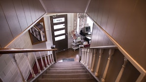 A staircase with a handrail, carpeted steps, and a door at the top. - Rosemount Motel (Bedford)