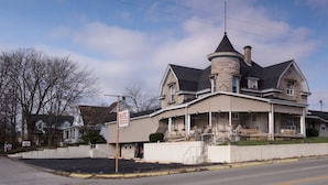 A large, historic building with a prominent turret and a porch, likely a hotel. - Rosemount Motel (Bedford)