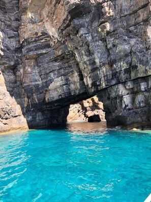 A natural rock formation with a clear blue pool underneath. - Triton Authentic Cretan Hotel (Minoa Pediada)
