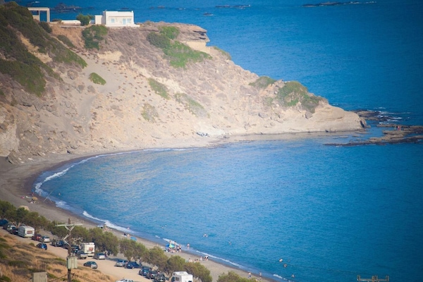 Una playa cerca, sillas reclinables de playa, sombrillas