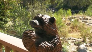 Una terraza de madera con una escultura de oso.