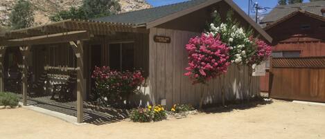 A rustic building with a wooden exterior, a covered porch with chairs, and a sign reading "Visitor's Park."