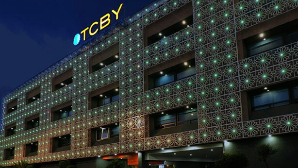 Een hotel met meerdere verdiepingen, een decoratieve gevel en verlichte ramen.