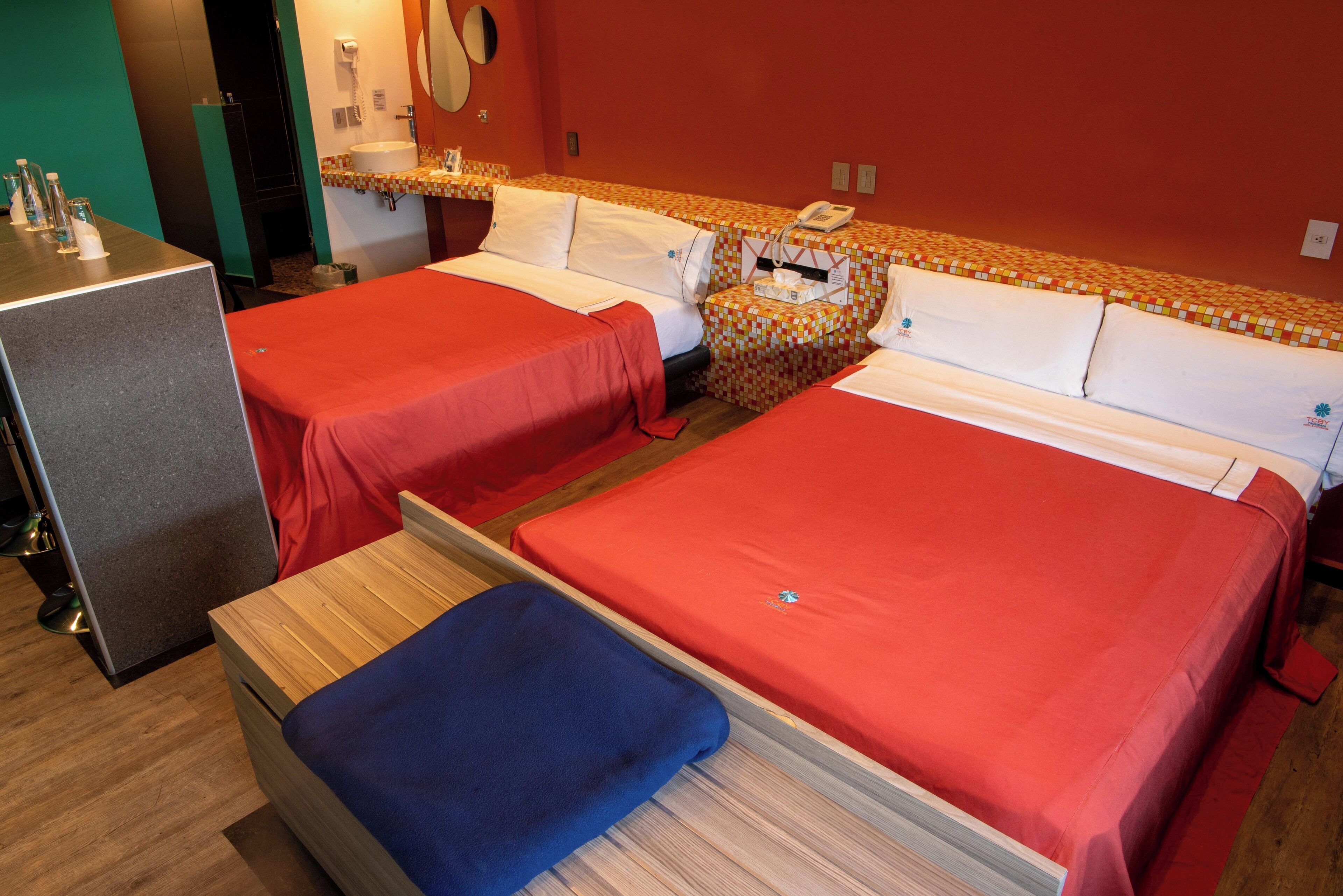 Een hotelkamer met twee bedden, een bureau en een spiegel.