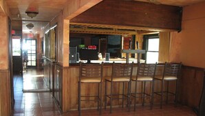 Una zona de bar con sillas de madera y una barra.