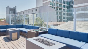 A rooftop lounge with blue seating and a fire feature. - The Davis Downtown San Diego (San Diego)