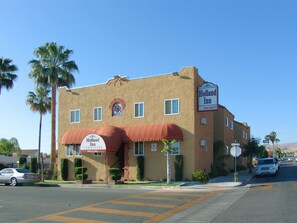 Un bâtiment à deux étages, doté d’un auvent rouge et d’une enseigne indiquant « Holland Inn and Suites », ainsi qu’une autre enseigne indiquant « Chambres disponibles ».