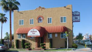 Un edificio de dos pisos con toldo rojo y un letrero que dice 'Holland Inn and Suites'.