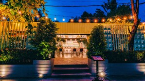 A restaurant with outdoor seating, a bar area, and a staircase leading up to the entrance.