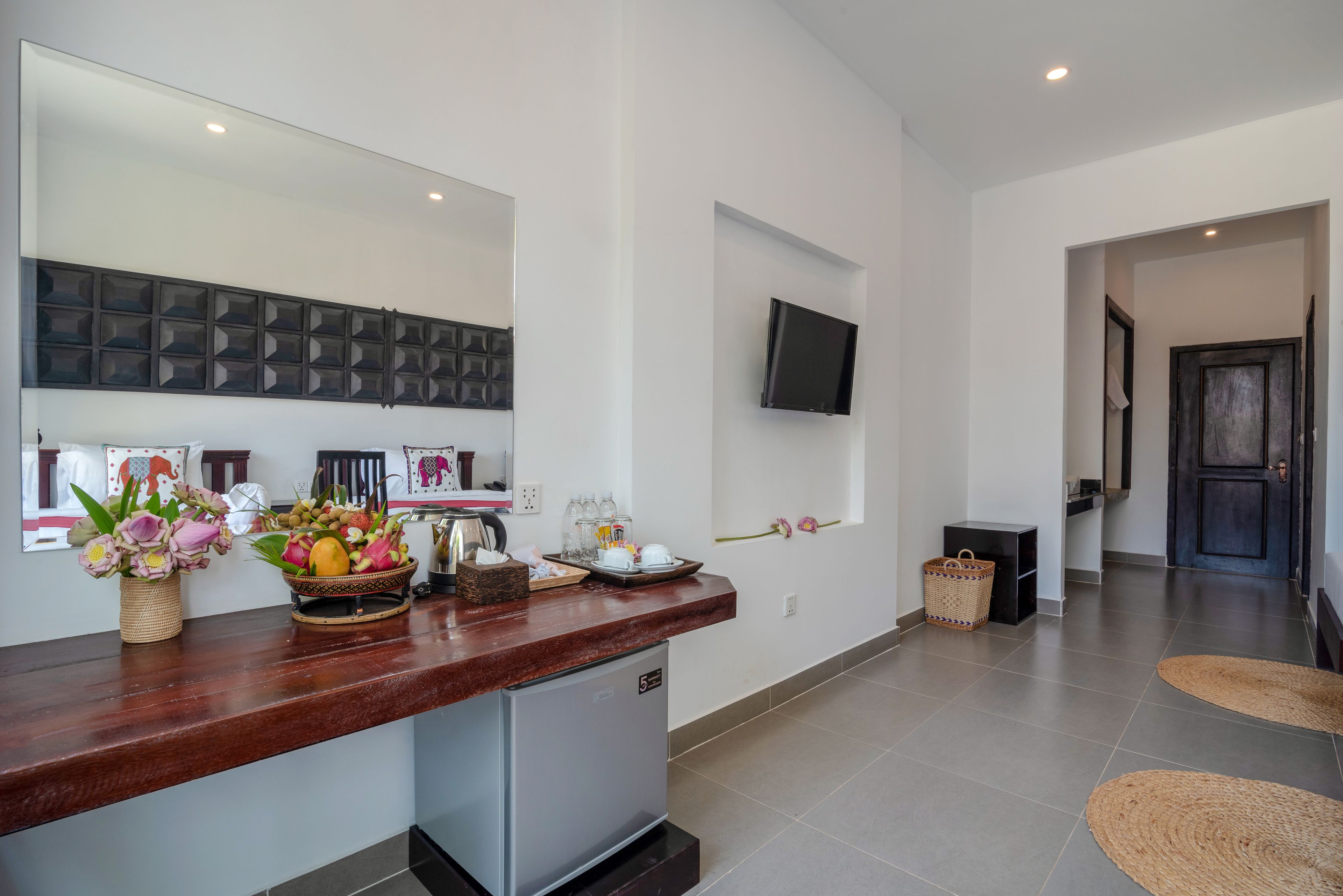 A modern kitchen with a built-in refrigerator, a wooden countertop, and a wall-mounted TV.